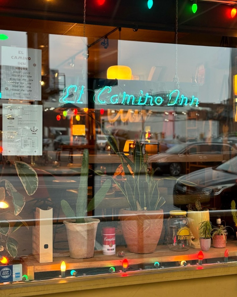 a neon sign reading el camino inn