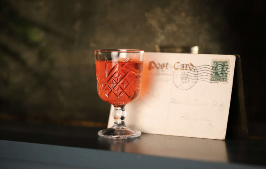 cocktail in front of vintage postcard